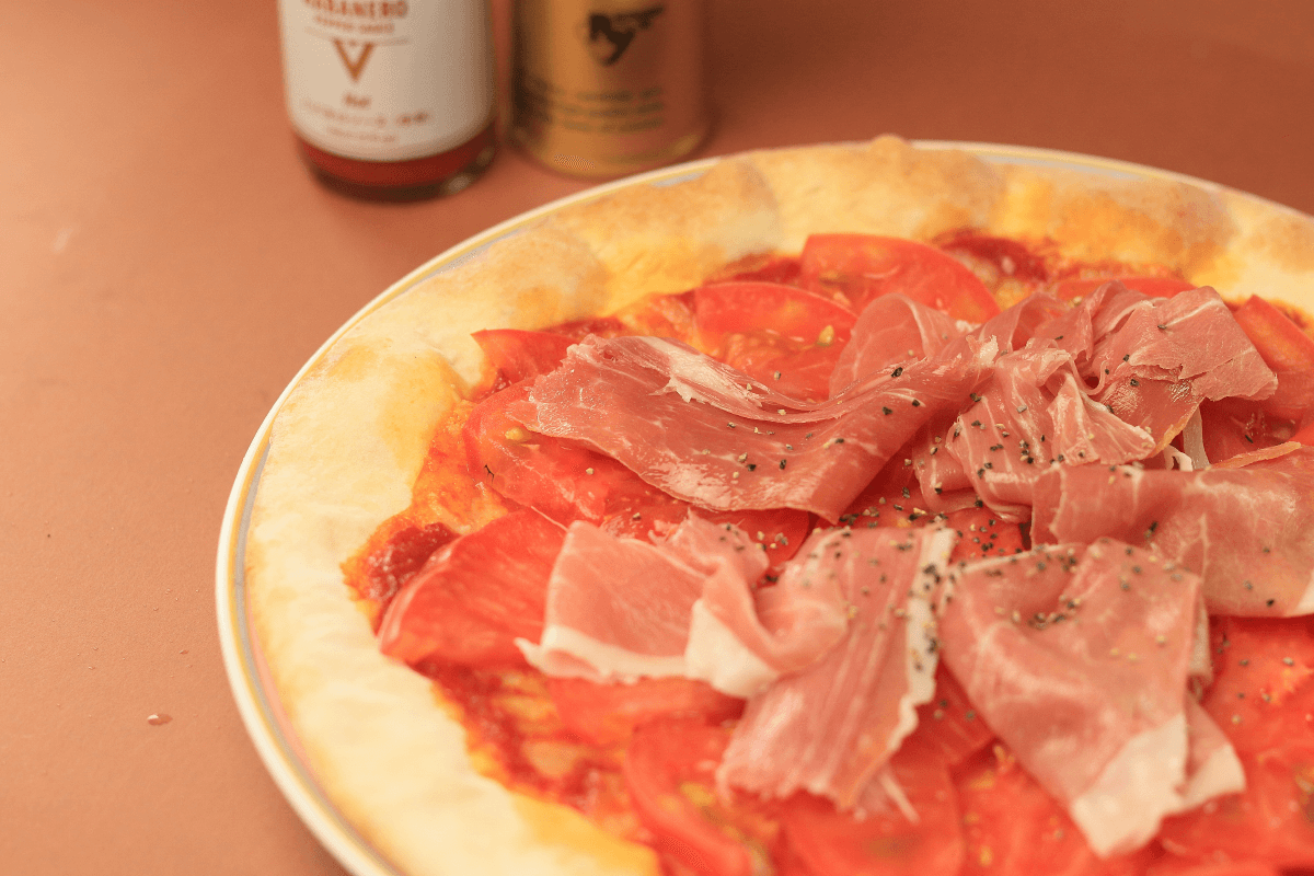 Raw ham and tomato pizza